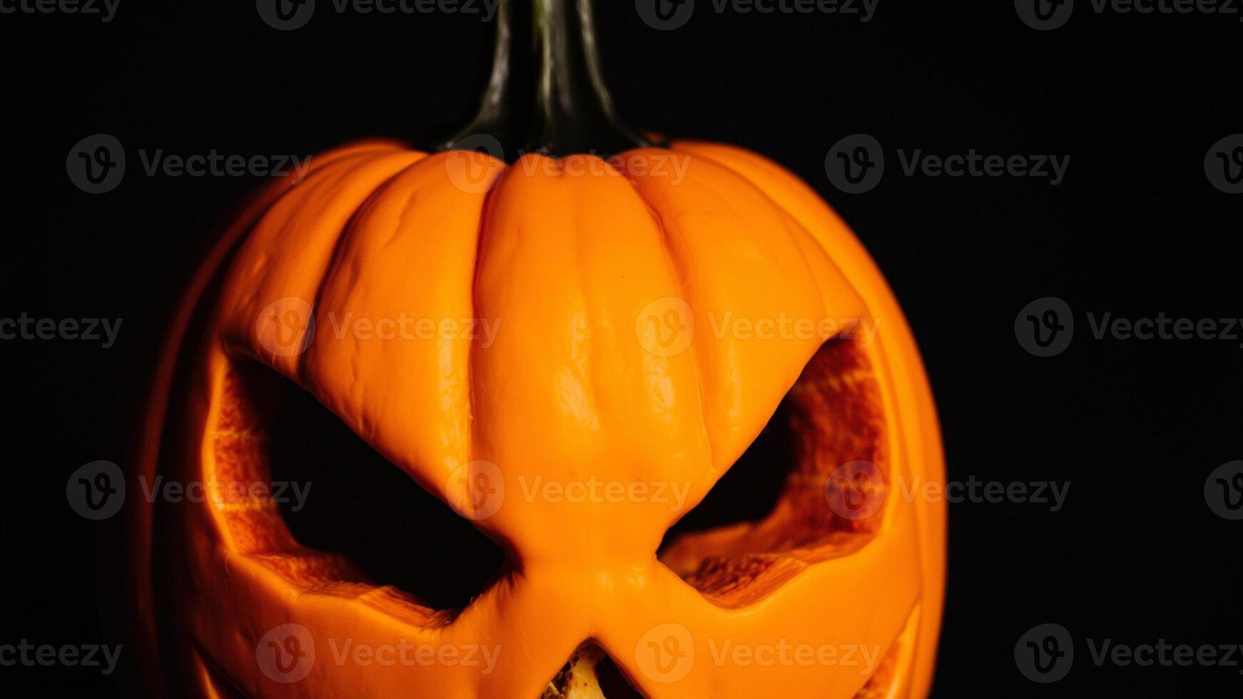 Closeup of a Carved Pumpkin with Glowing Eyes photo