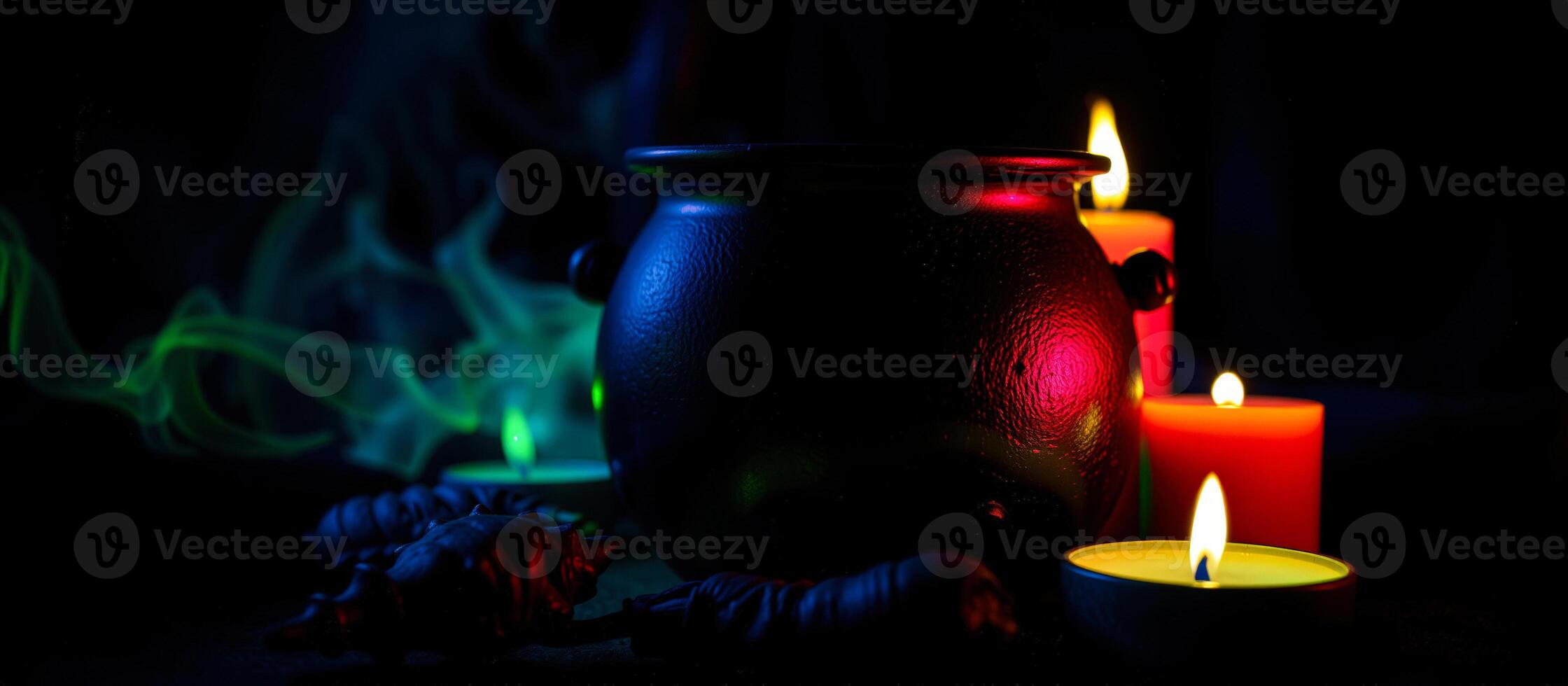 black cauldron with burning candles green smoke photo