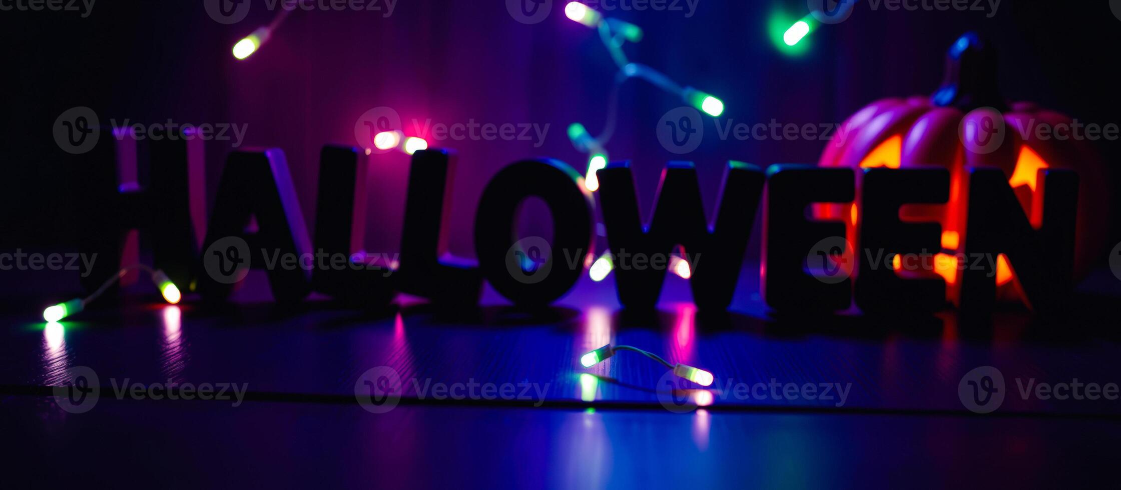 dark moody halloween scene with a carved pumpkin lights photo