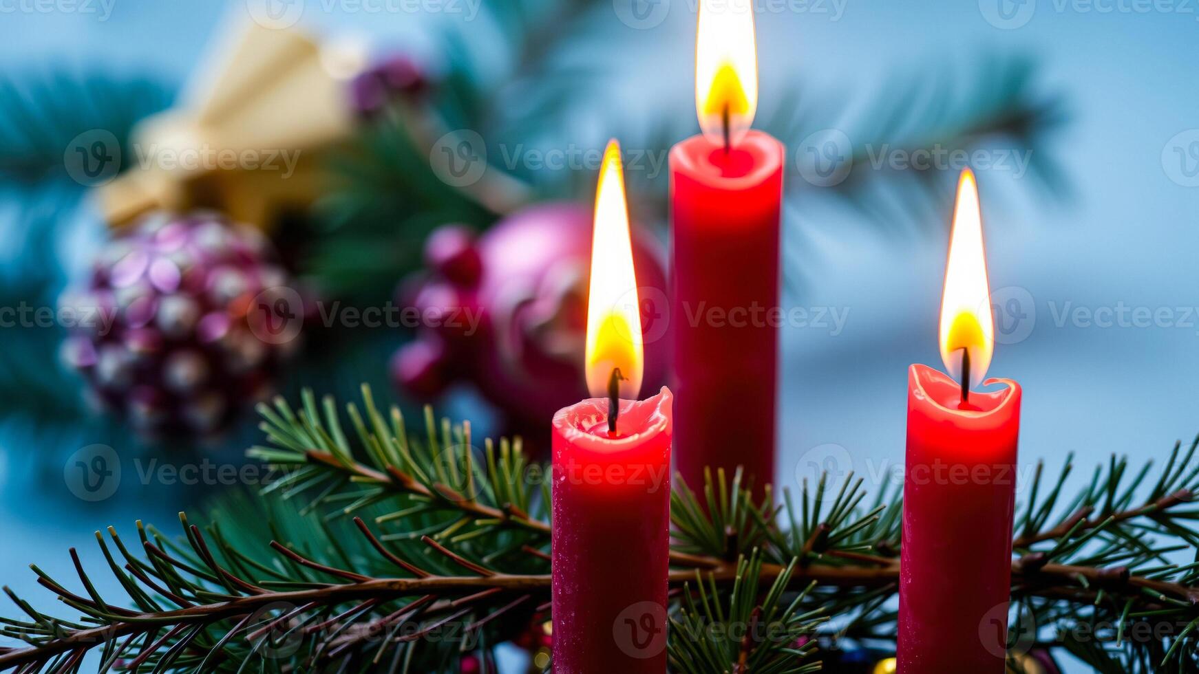 three red candles glowing on a pine branch photo