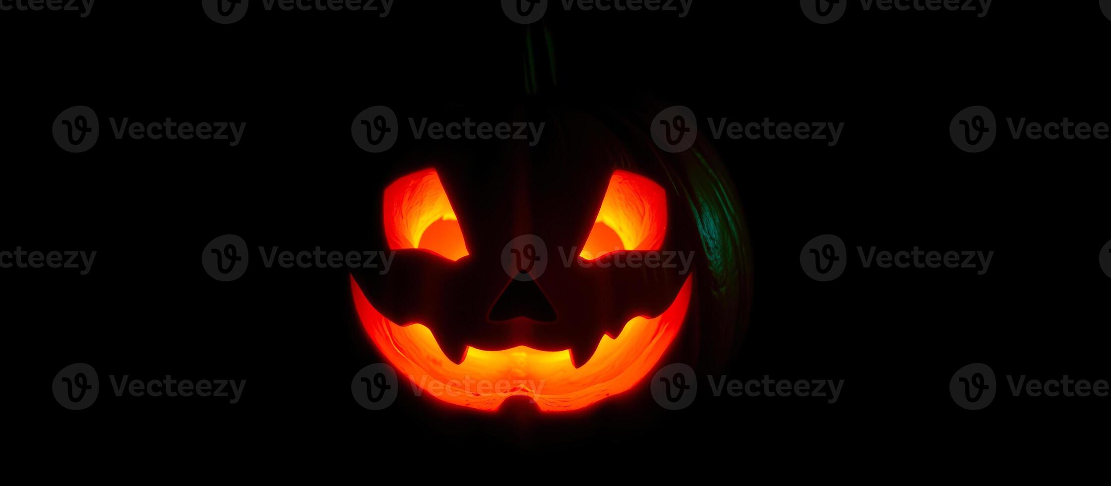 carved pumpkin glows with a menacing grin photo