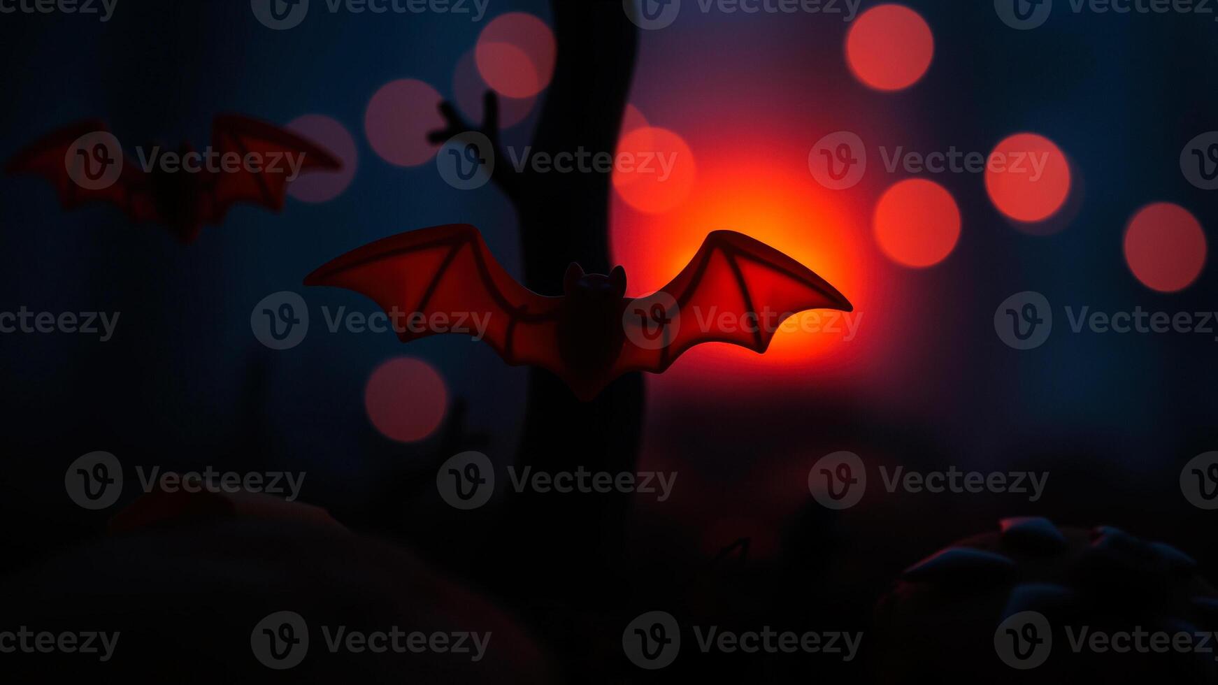 red plastic bat flies against a blurred background lights photo