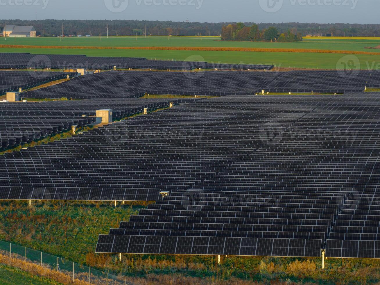 Expansive Solar Panel Farm in Lithuania with Lush Green Fields photo