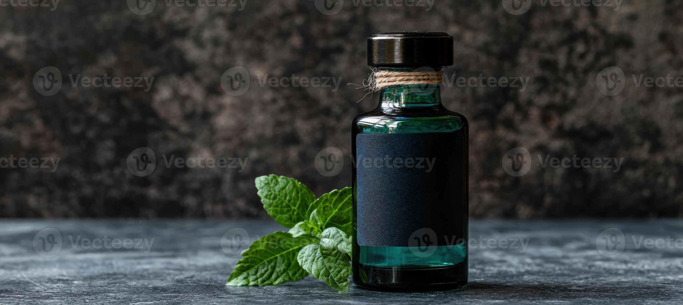 Bottle of green herbal tincture with fresh mint leaves photo
