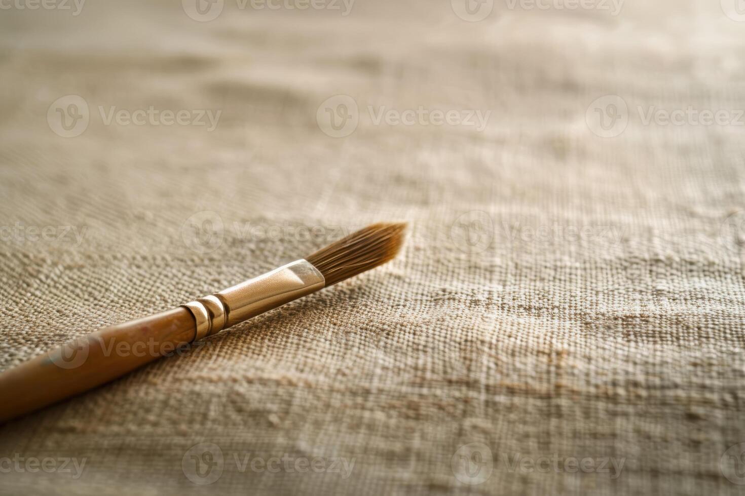 Closeup of a paintbrush on a textured fabric background photo