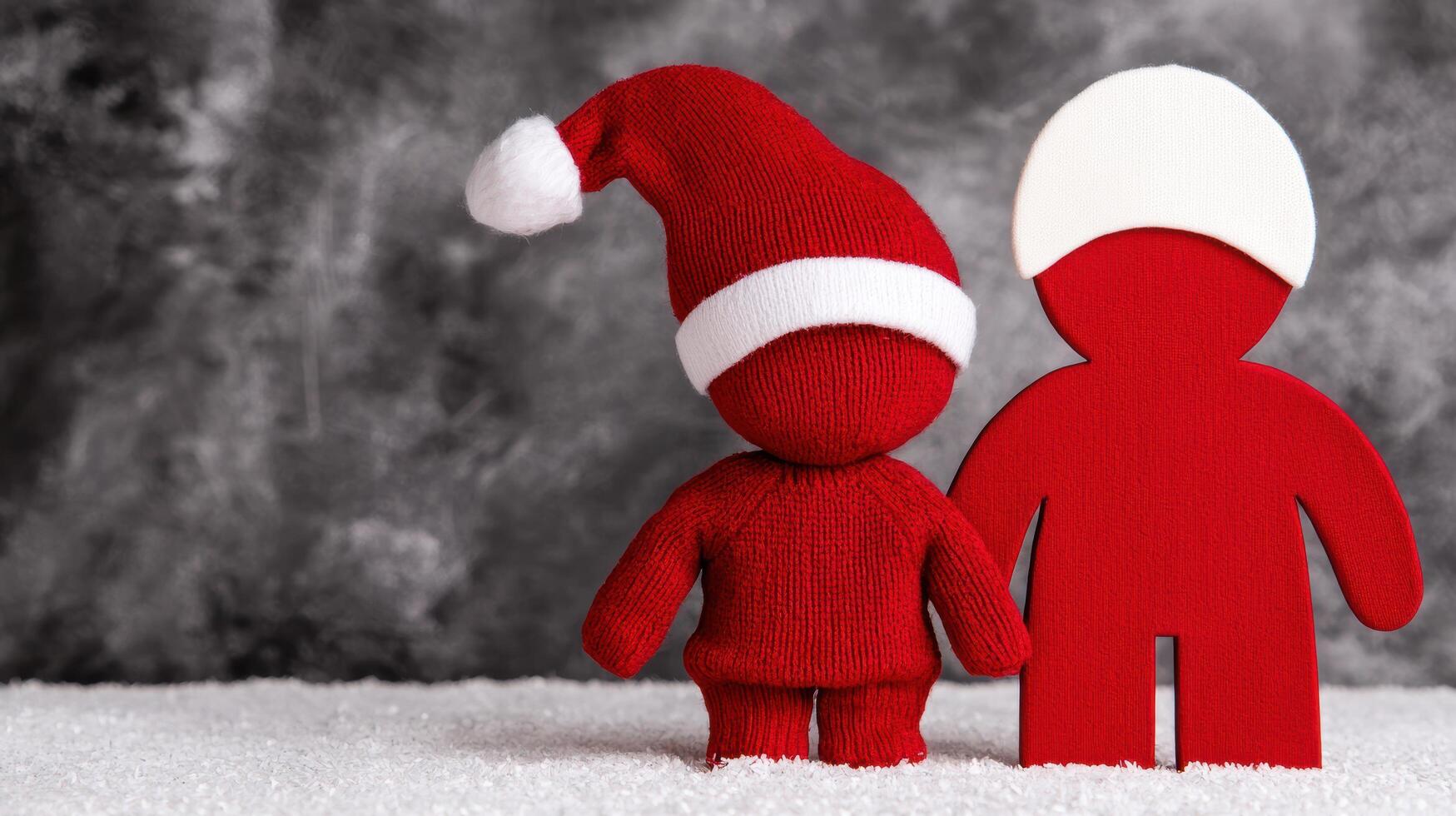 two red and white knitted christmas characters in the snow photo