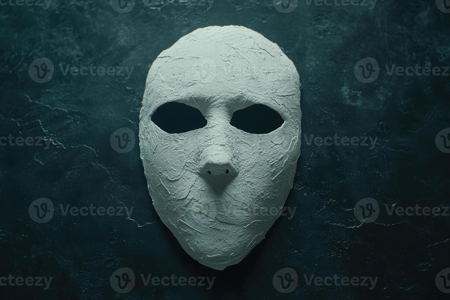 Mysterious white mask on dark background photo