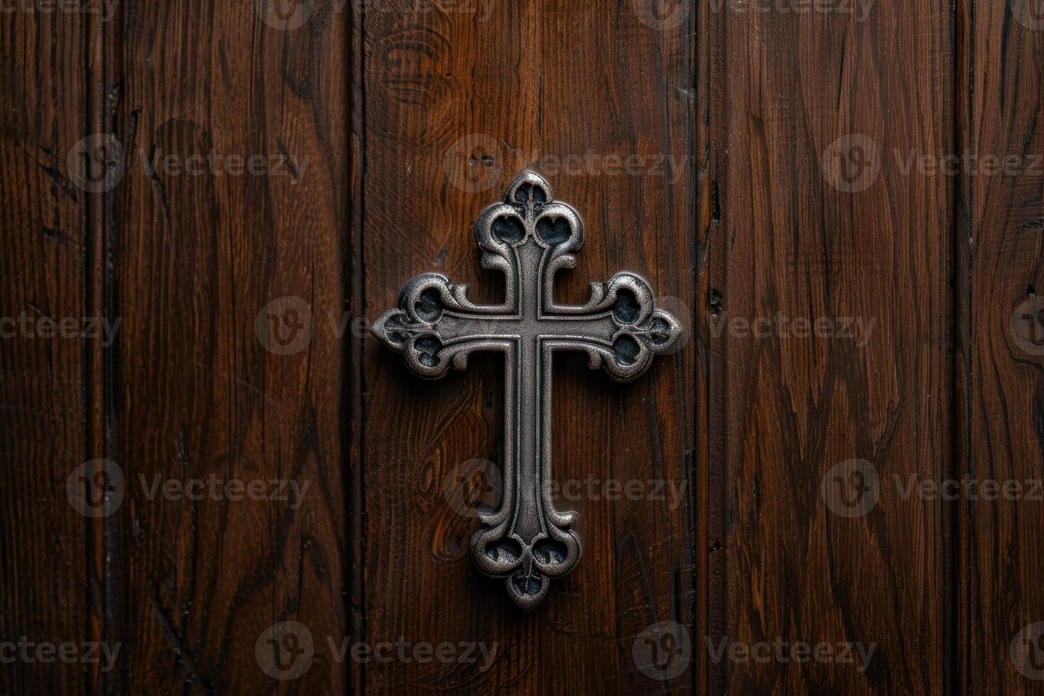 Ornate metal cross on weathered wooden background photo