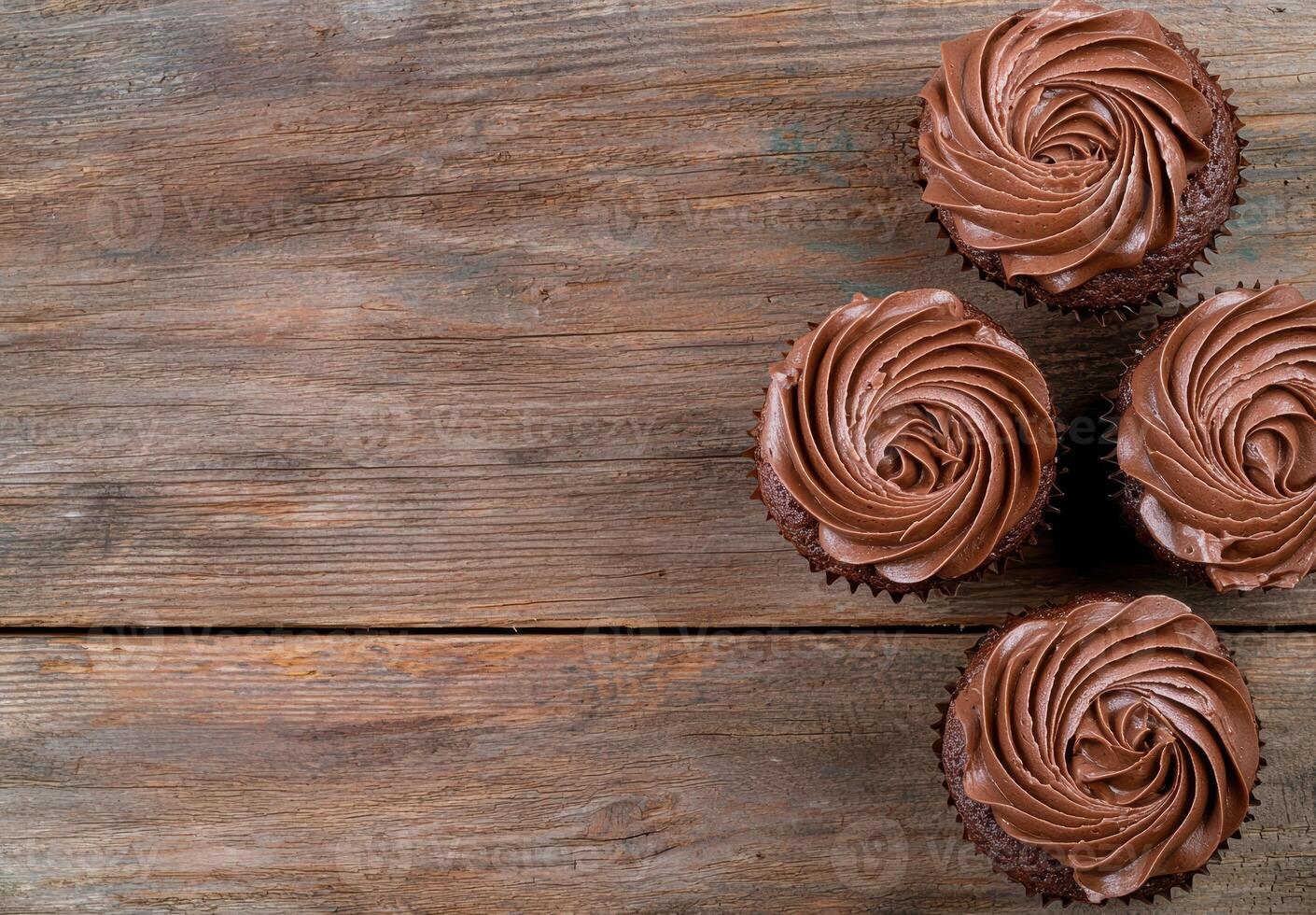 Delicious chocolate cupcakes with swirled frosting on a rustic wooden background photo