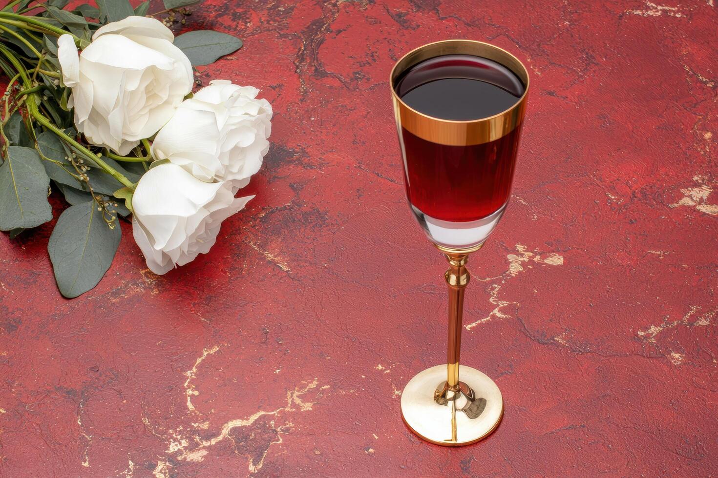 elegant glass of red wine with white roses on red marble background photo