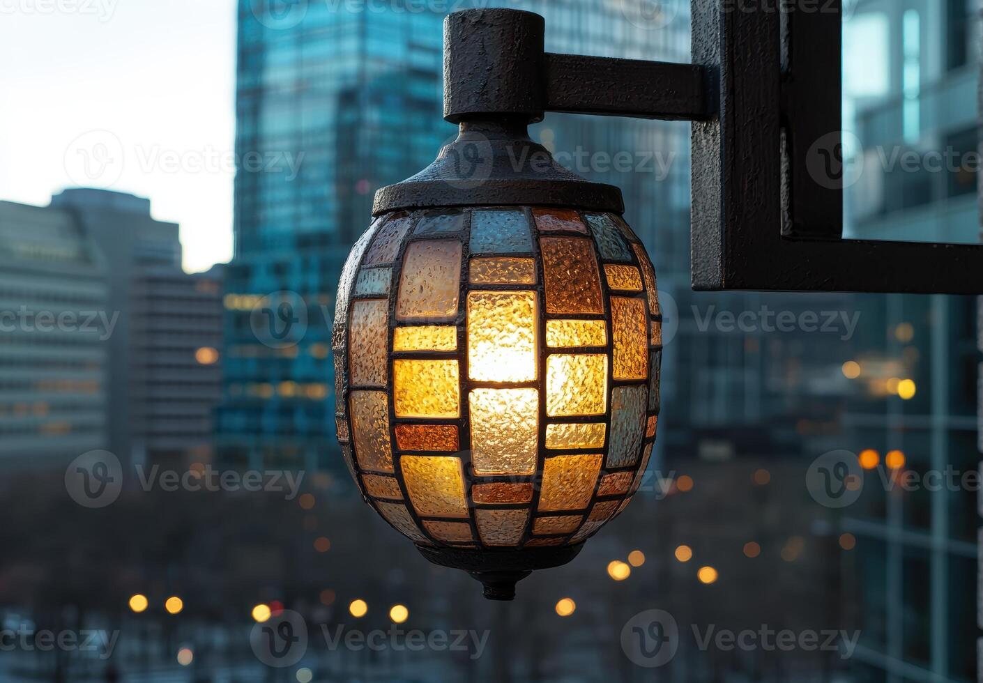 Illuminated glass lantern against blurred city skyline photo