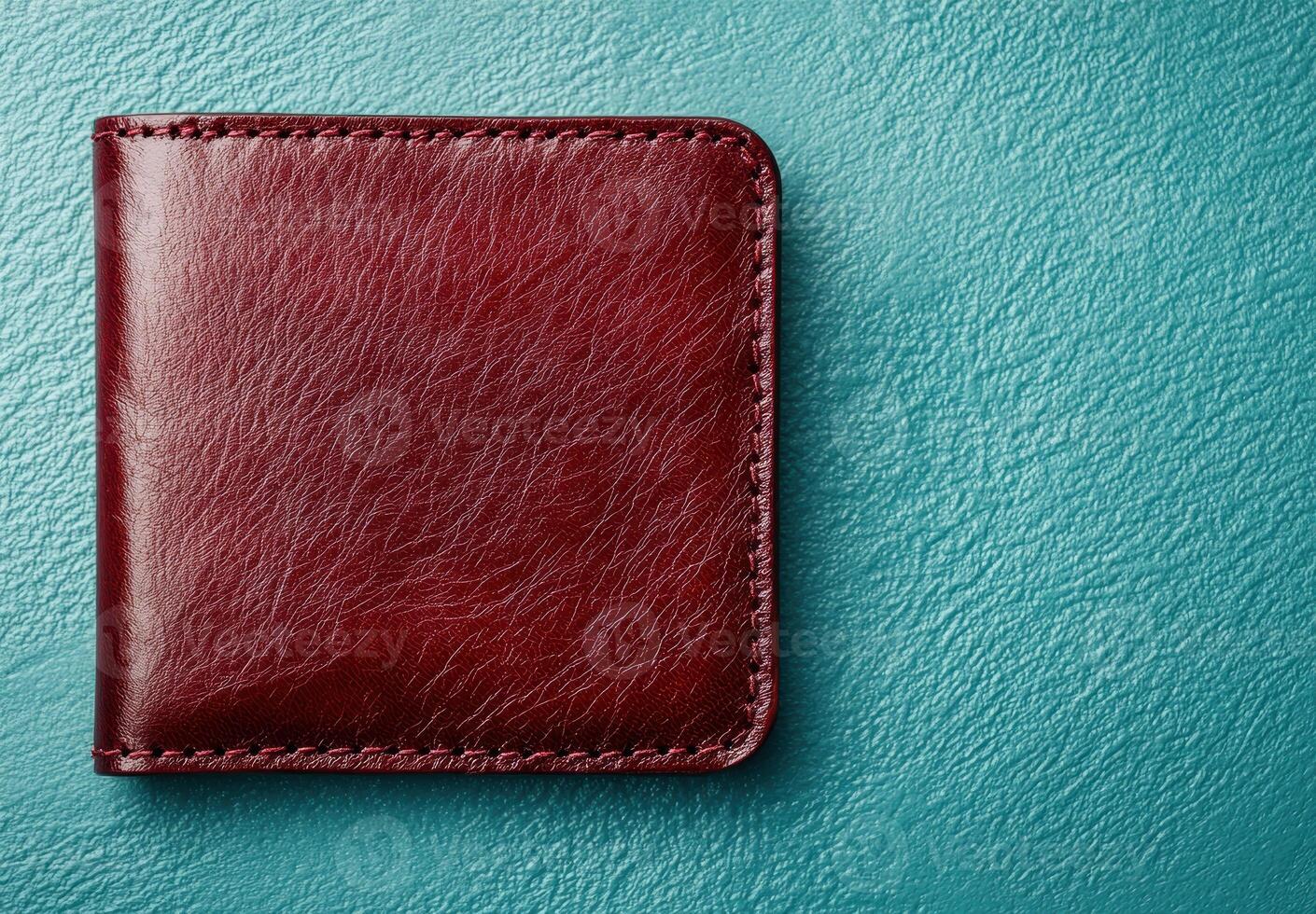 Burgundy leather wallet on teal background photo
