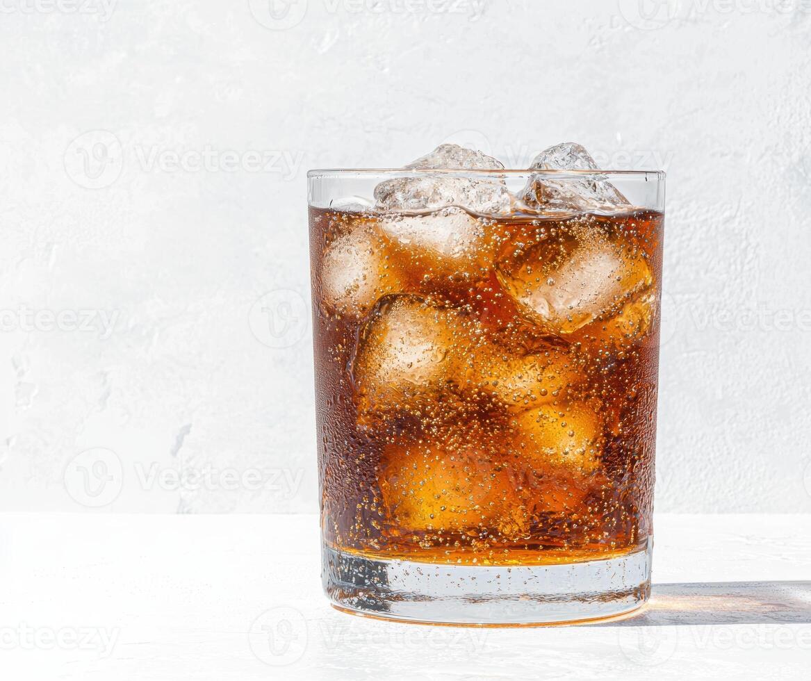 Refreshing glass of iced cola drink with ice cubes photo