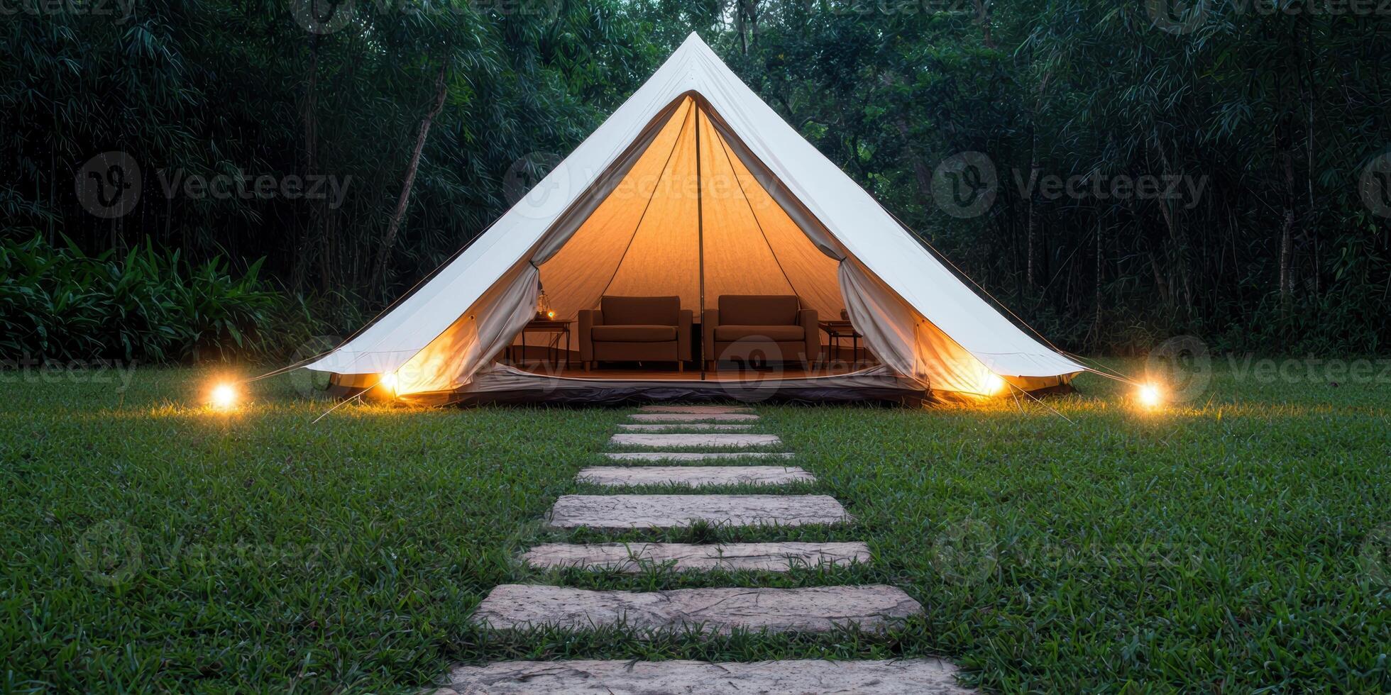 Cozy glamping tent in lush forest at night photo