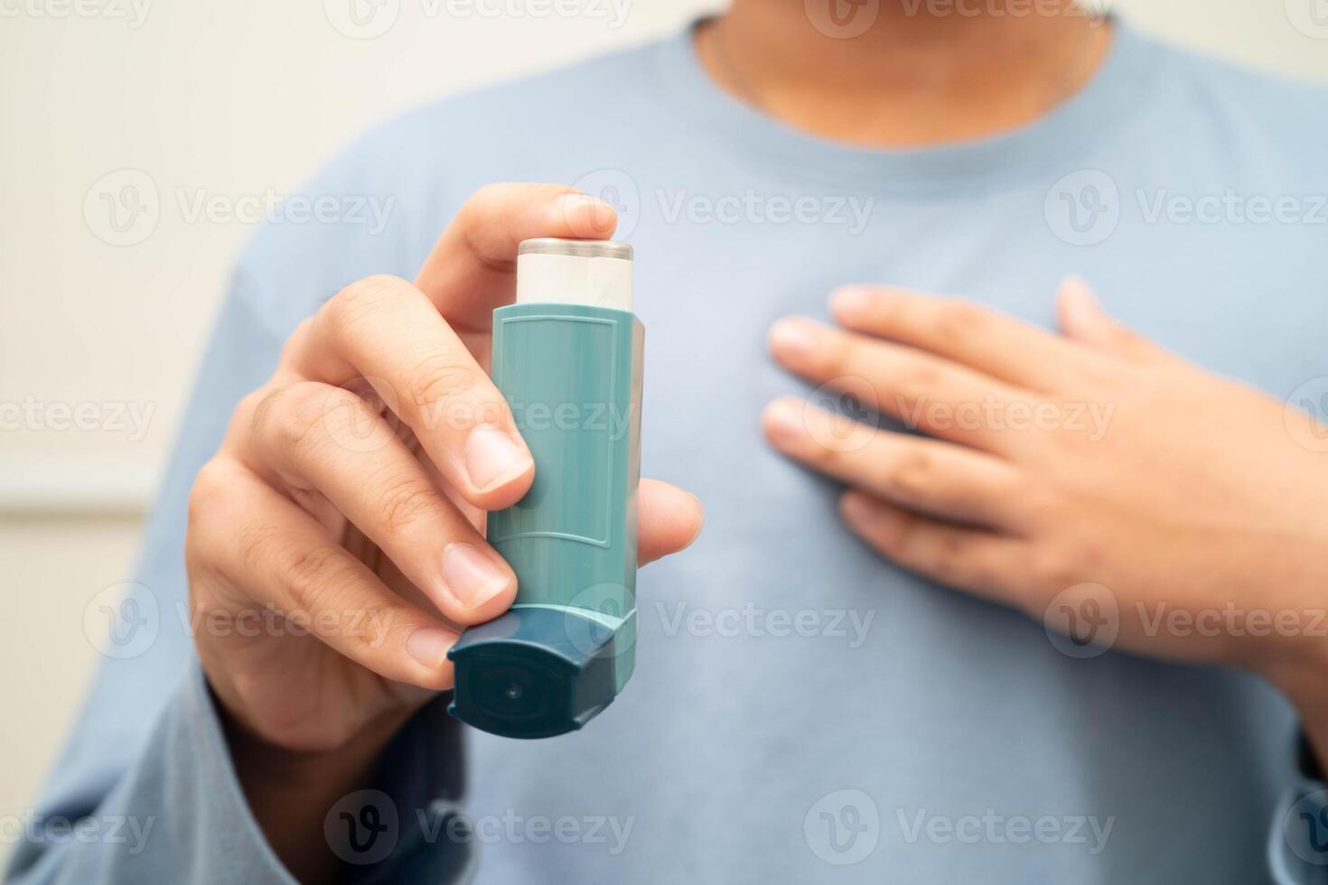 Asthma and chronic obstructive pulmonary disease COPD, Asian young man using metered dose inhaler MDI. photo