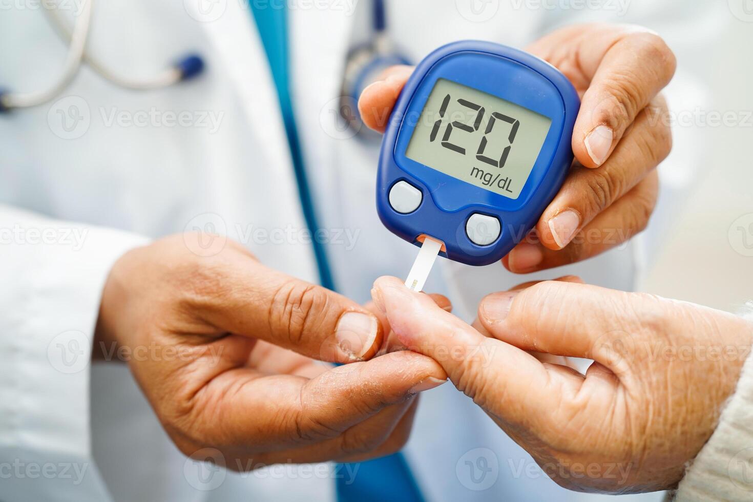 Asian doctor using digital glucose meter for check sample blood sugar level to treatment diabetes. photo