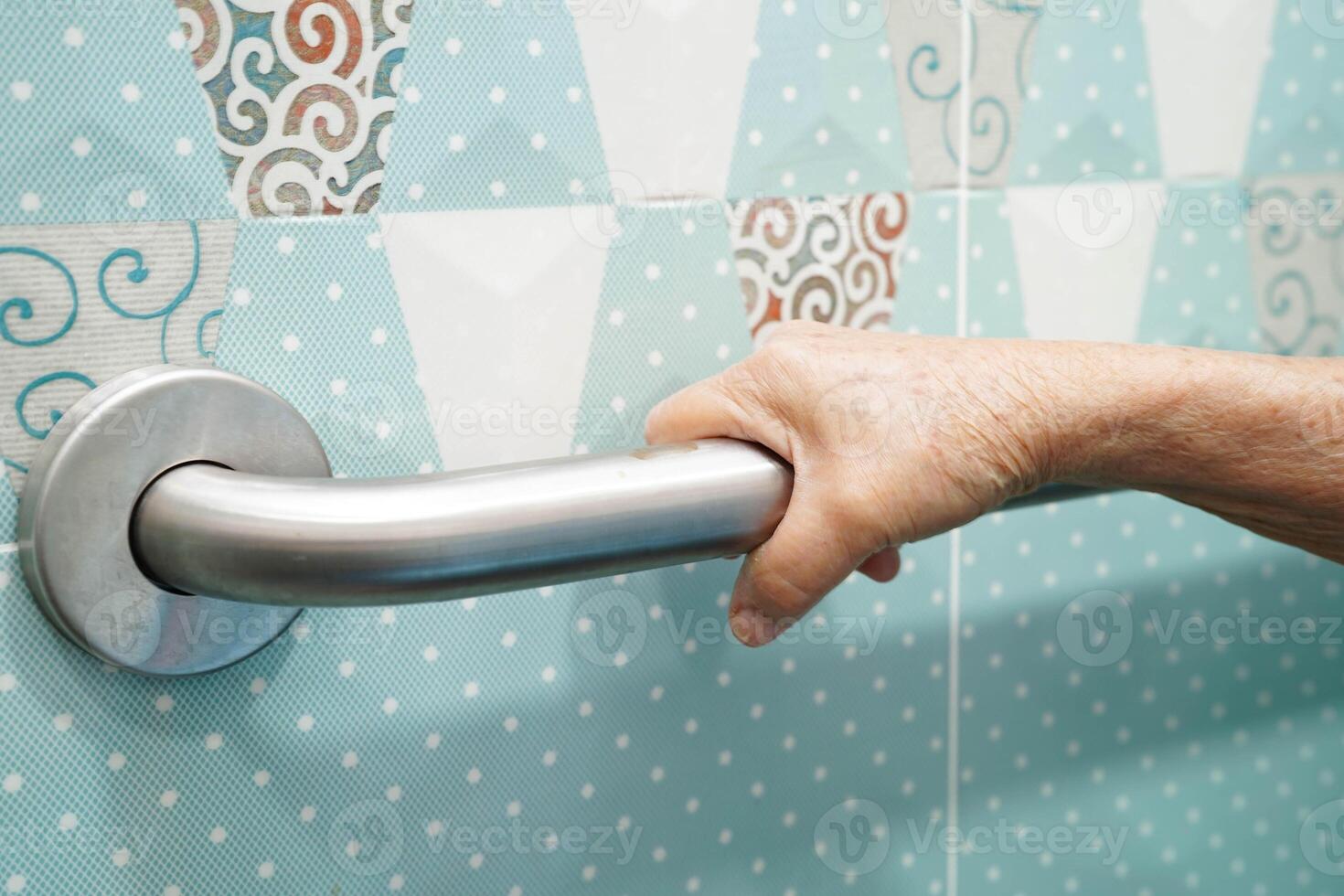 Asian elderly old woman patient use toilet support rail in bathroom, handrail safety grab bar, security in nursing hospital. photo