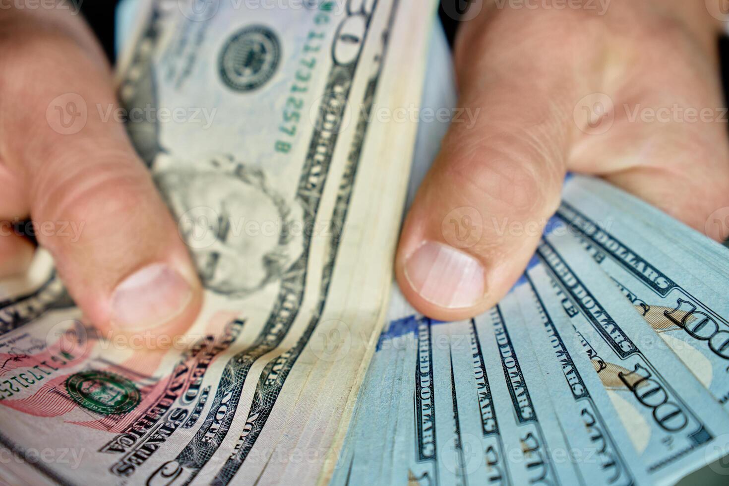Man counting stack of dollar bills photo
