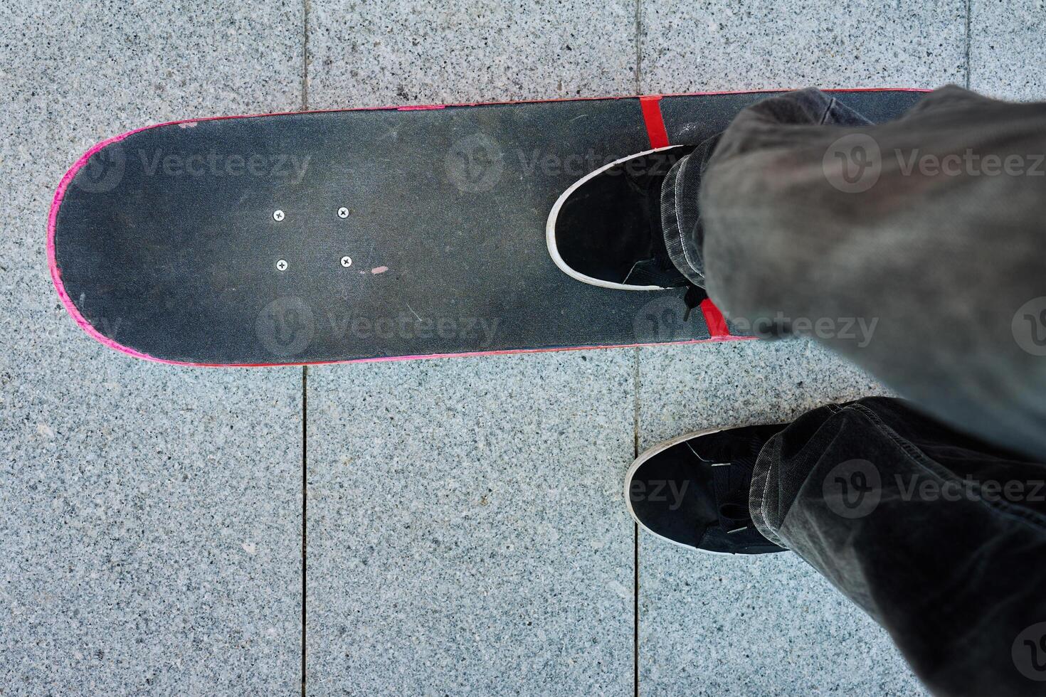 Top view of skateboarder riding on skateboard on road photo