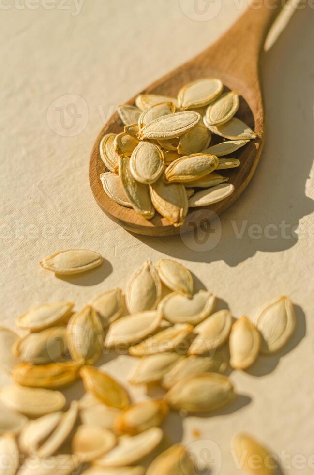 Unpeeled pumpkin seeds in wooden spoon . Top view. High quality photo