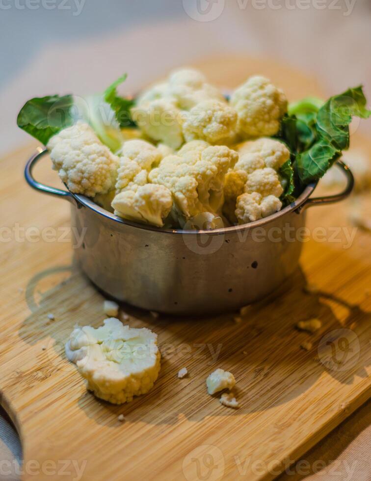 Raw and fresh cauliflower in pot on the table of the kitchen to be cooked. High quality photo