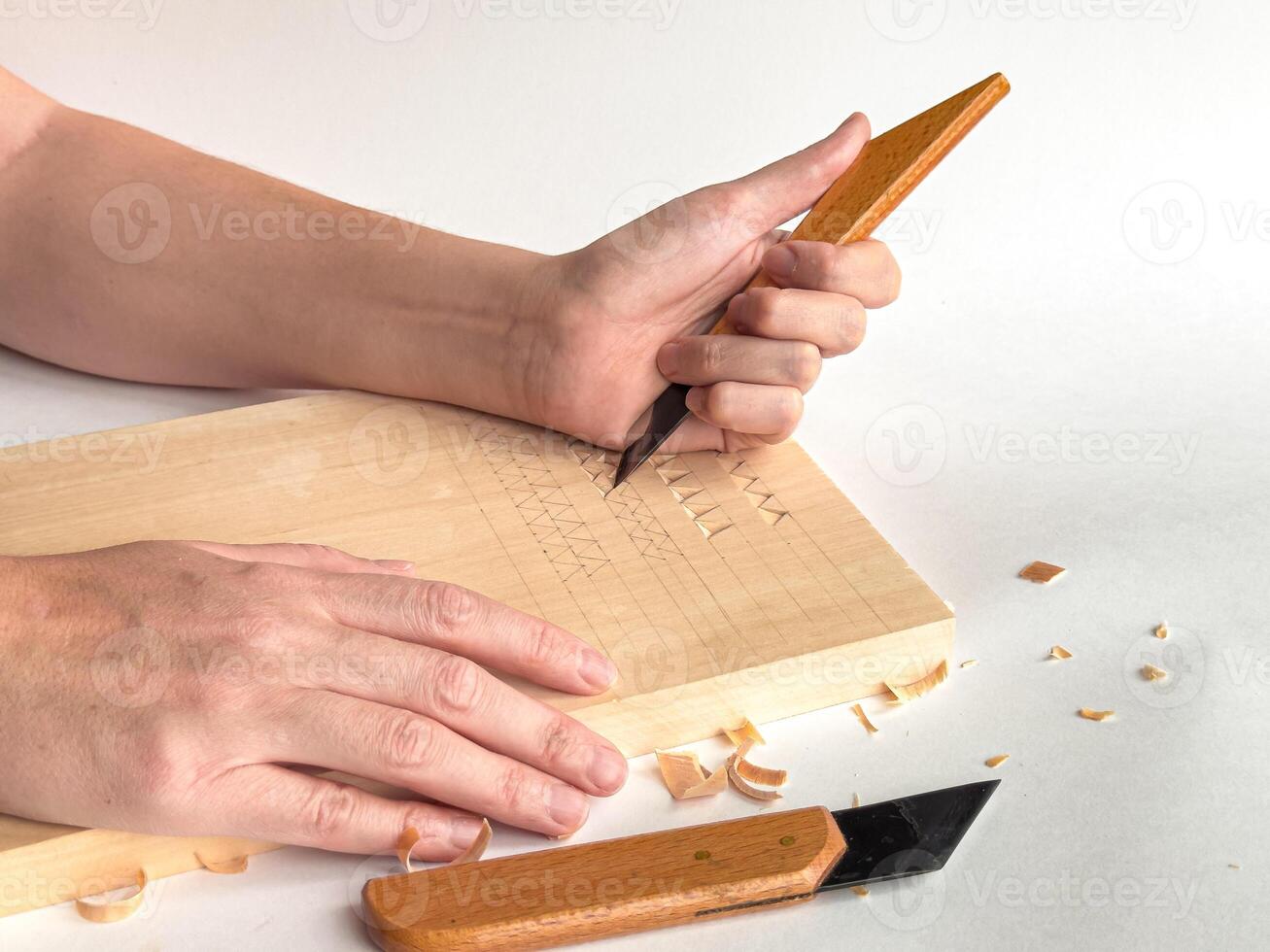 Precision woodcarving techniques. Hands crafting intricate patterns on wood photo