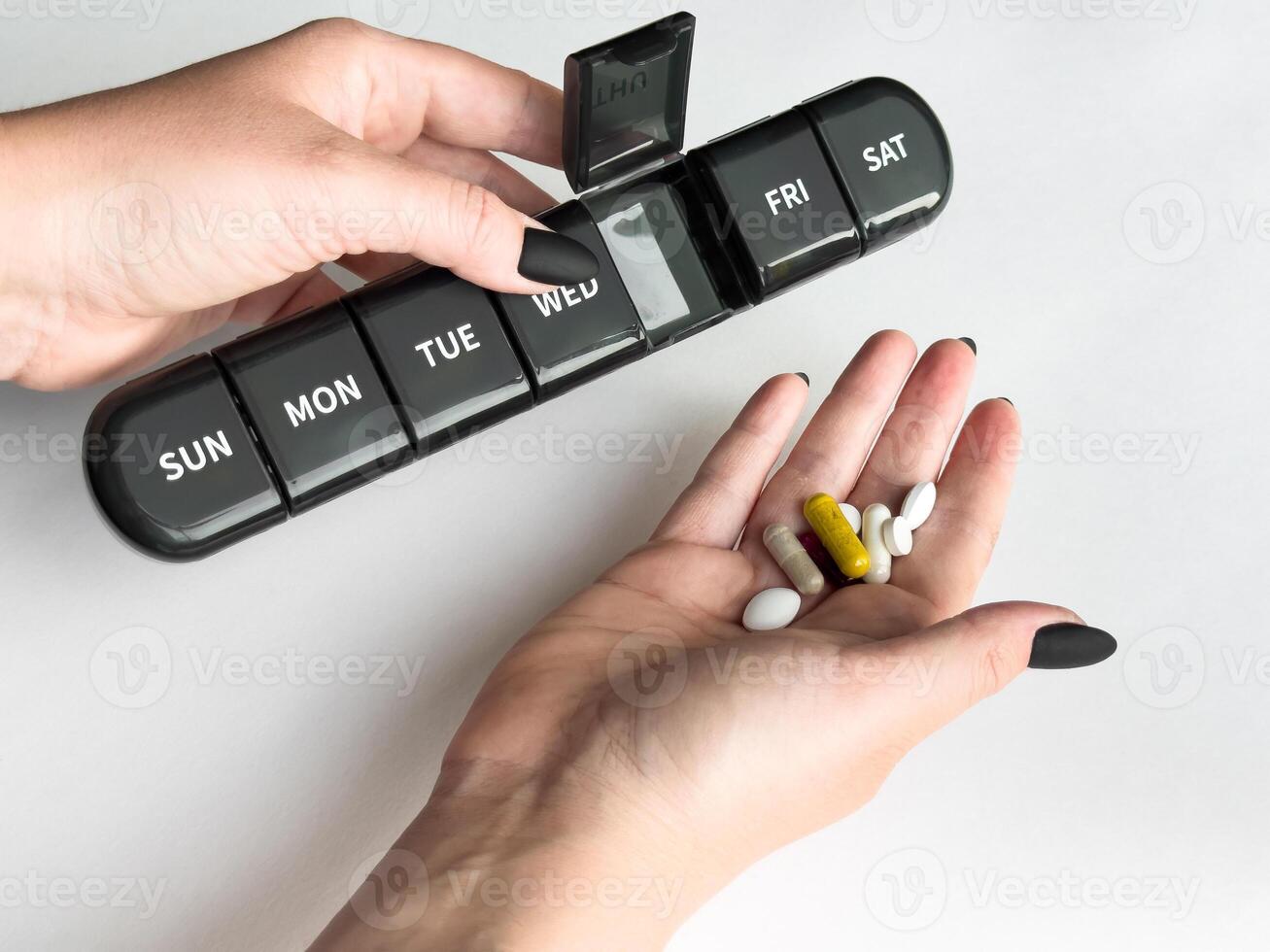 Weekly pill organizer and assorted supplements for daily health routine photo