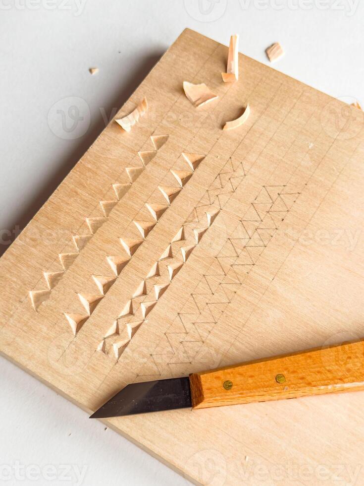 Wood carving techniques on softwood with precision knife and geometric patterns photo