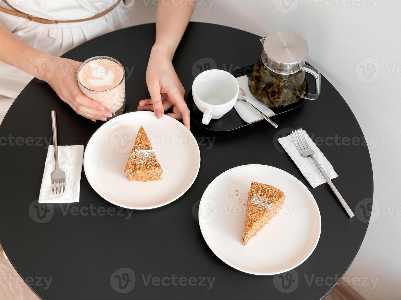 Cozy cafe setting with tea and cake slices on a round table photo