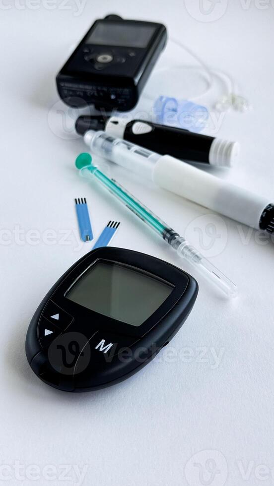 Diabetes monitoring tools, glucometer, insulin pen, insulin pump, test strips, and syringe on white background photo