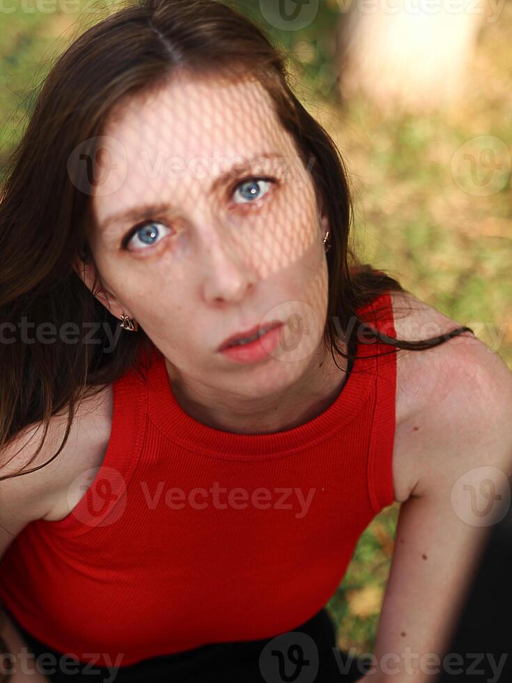 portrait of a young woman with blue eyes looking seriously at the camera. Avant-garde street portrait of a beautiful woman photo