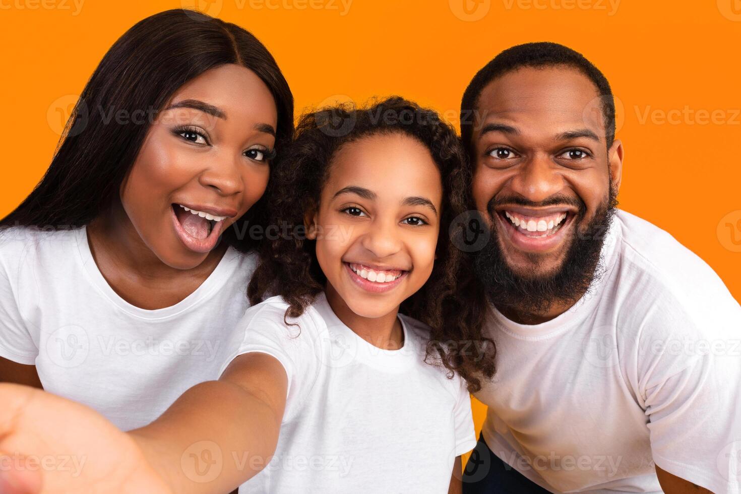 Portrait of happy african american family taking a selfie together. Excited parents posing with their daughter and smiling at camera, point of view. Bonding And Lifestyle Concept. photo
