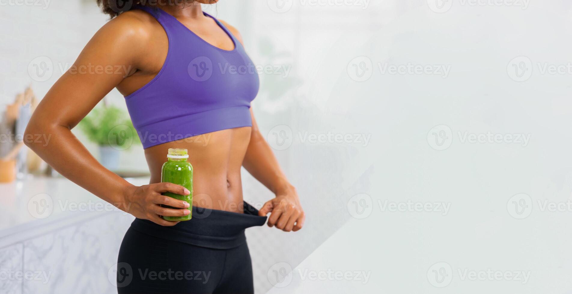 Unrecognizable Slim African Lady In Oversize Pants After Weight Loss Holding Bottle With Detox Smoothie, Copyspace photo