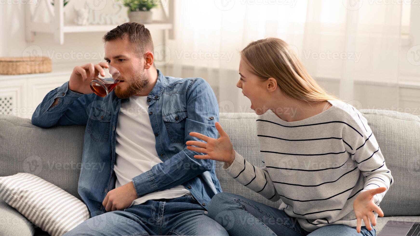 Drinking problem. Desperate woman arguing with drunk husband at home photo