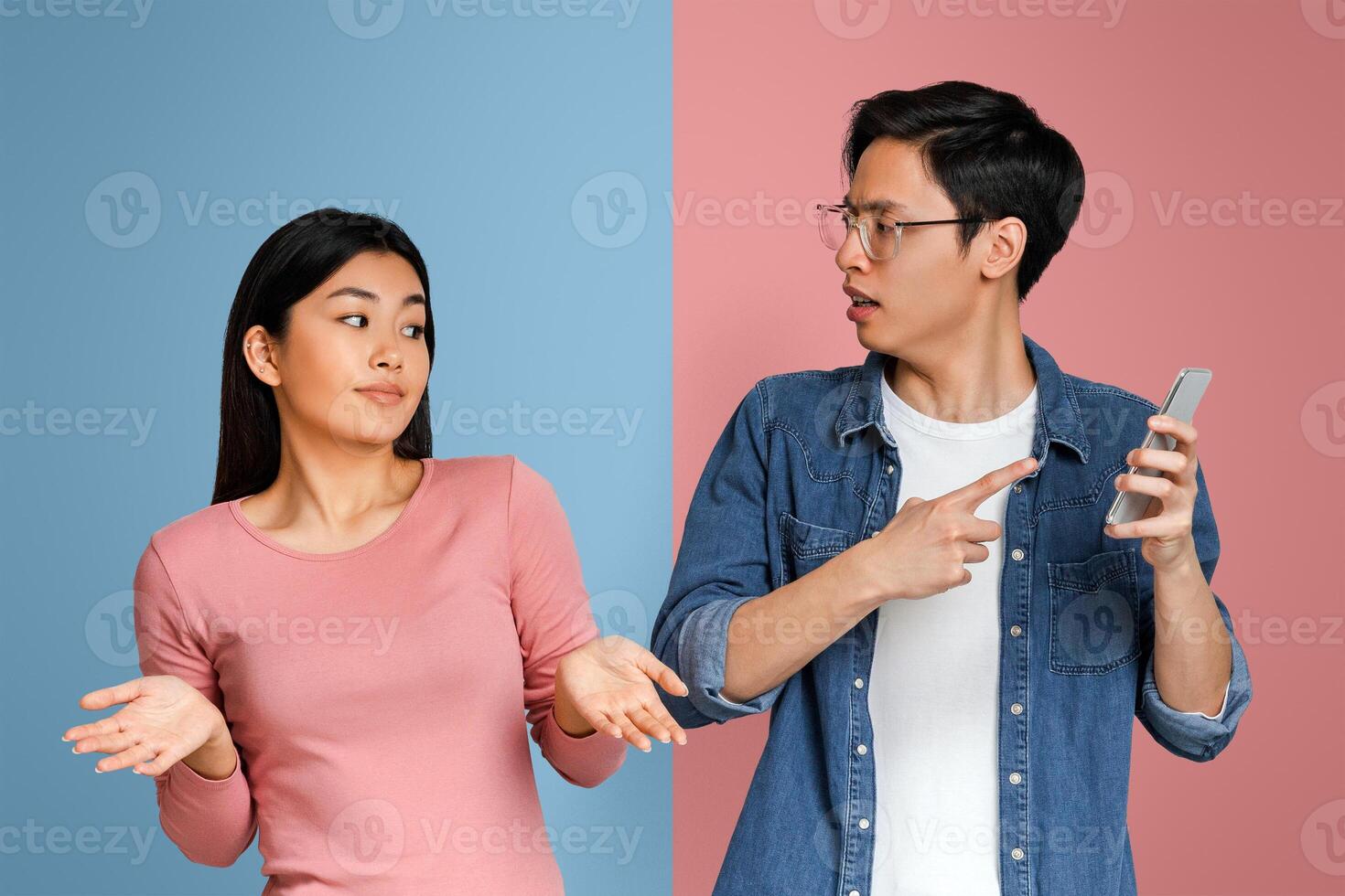 Who is this guy. Angry asian man checking his girlfriend mobile phone and asking her explanation photo