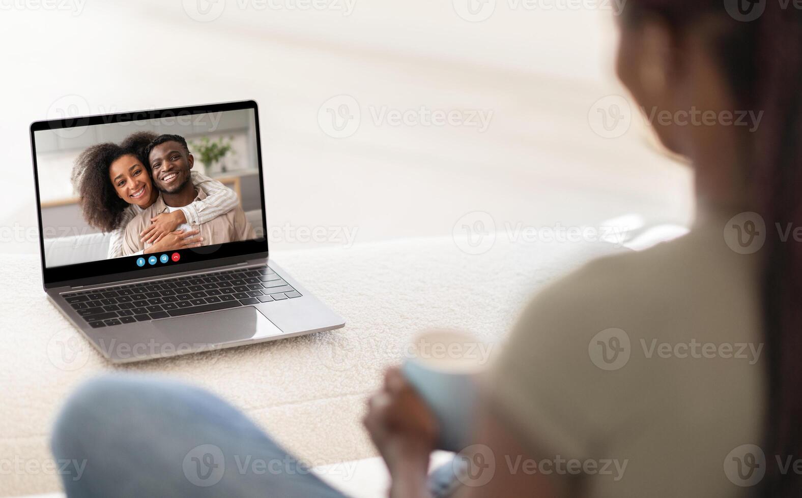 A person enjoys a heartfelt call with a loved one, embracing the warmth of connection from the comfort of their home. The cozy setting enhances the joyful interaction. photo