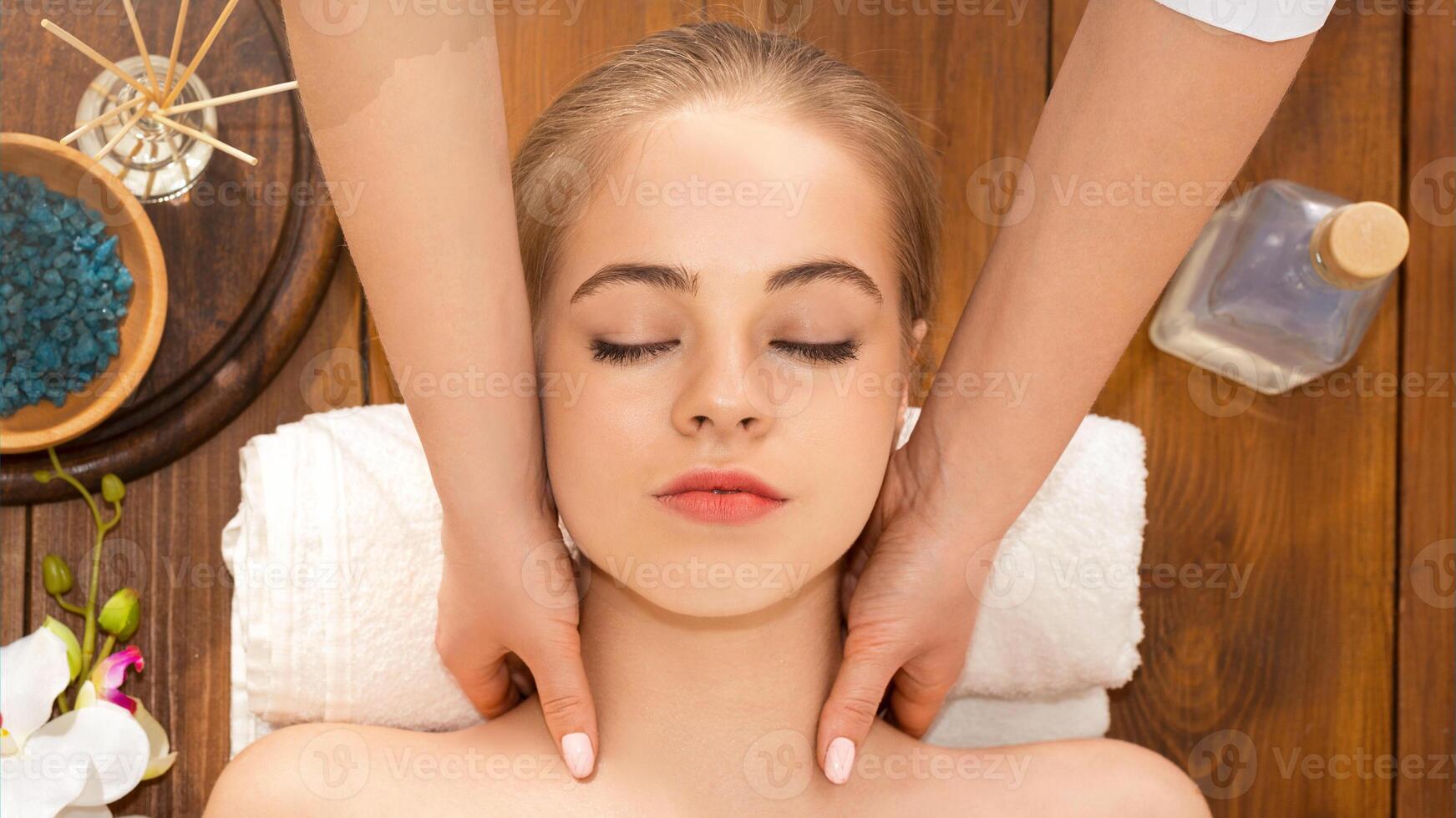Beautiful woman relaxing in spa salon and takes neck massage photo