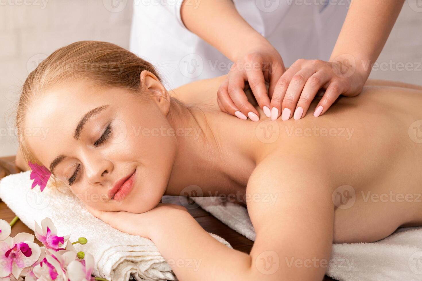 Manual masseur doing spa massage to young girl photo