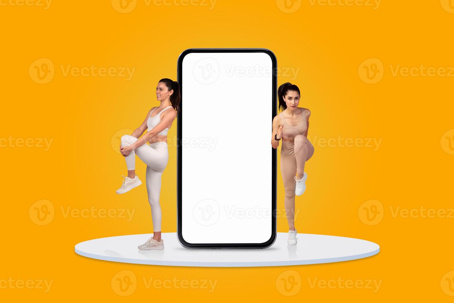 In a vibrant yellow setting, two women are engaged in fitness activities. One is lifting her knee while the other stands beside a large blank smartphone screen, promoting an active lifestyle. photo