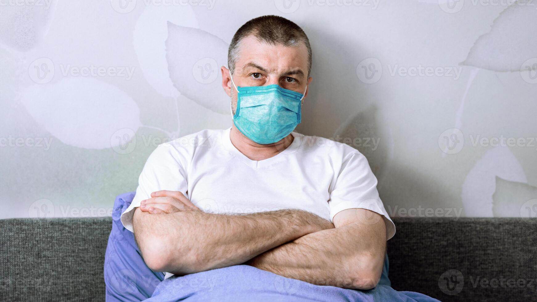 Endless Quarantine. Discontented Man In Medical Mask Sitting In Bed At Home Bored Of Homey Lifestyle And Social Distancing photo
