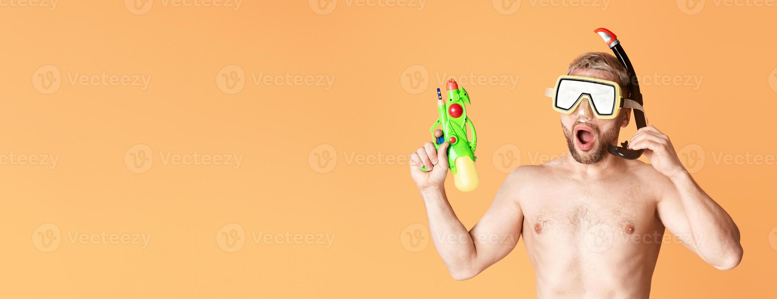 Guy with open mouth, with diving mask and water gun, free space photo