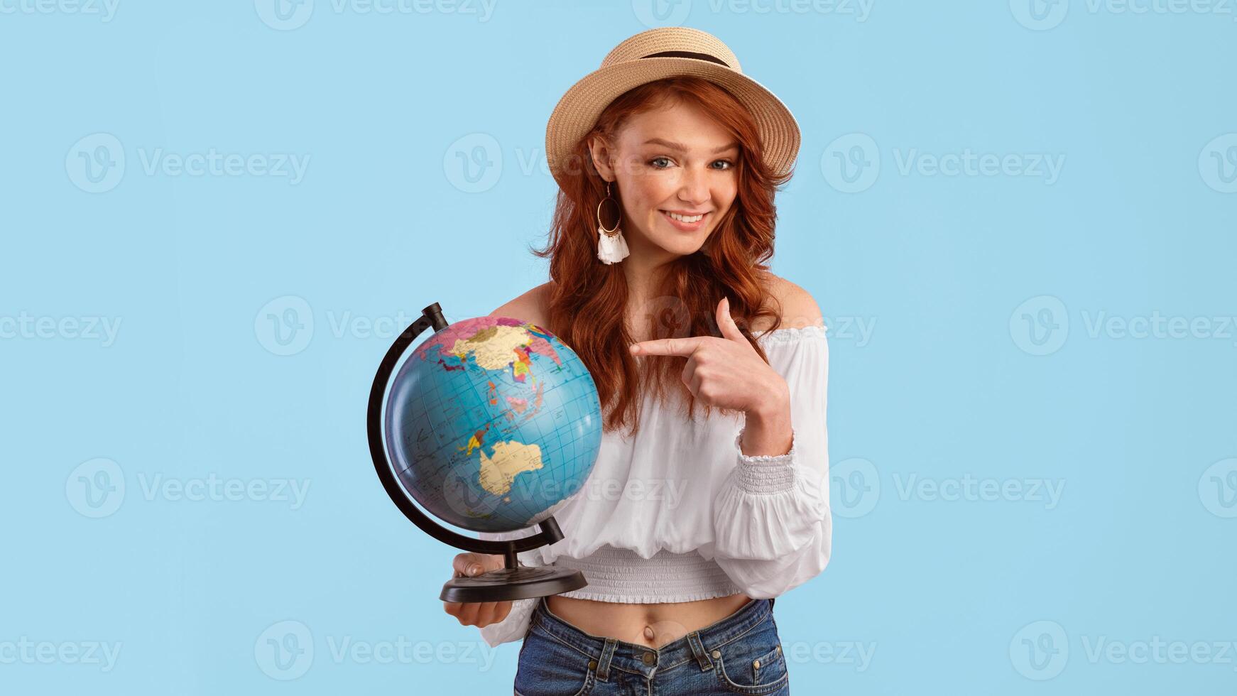 Planning Travel. Tourist Girl Holding World Globe Pointing Finger Standing Over Pink Studio Background. Panorama photo