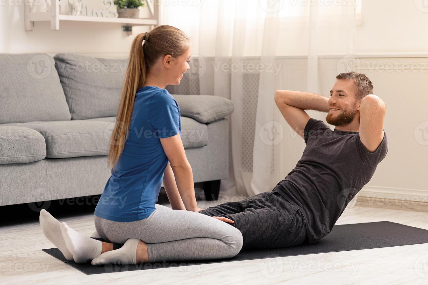 Spoty self-isolation. Young couple training at home on quarantine, free space photo