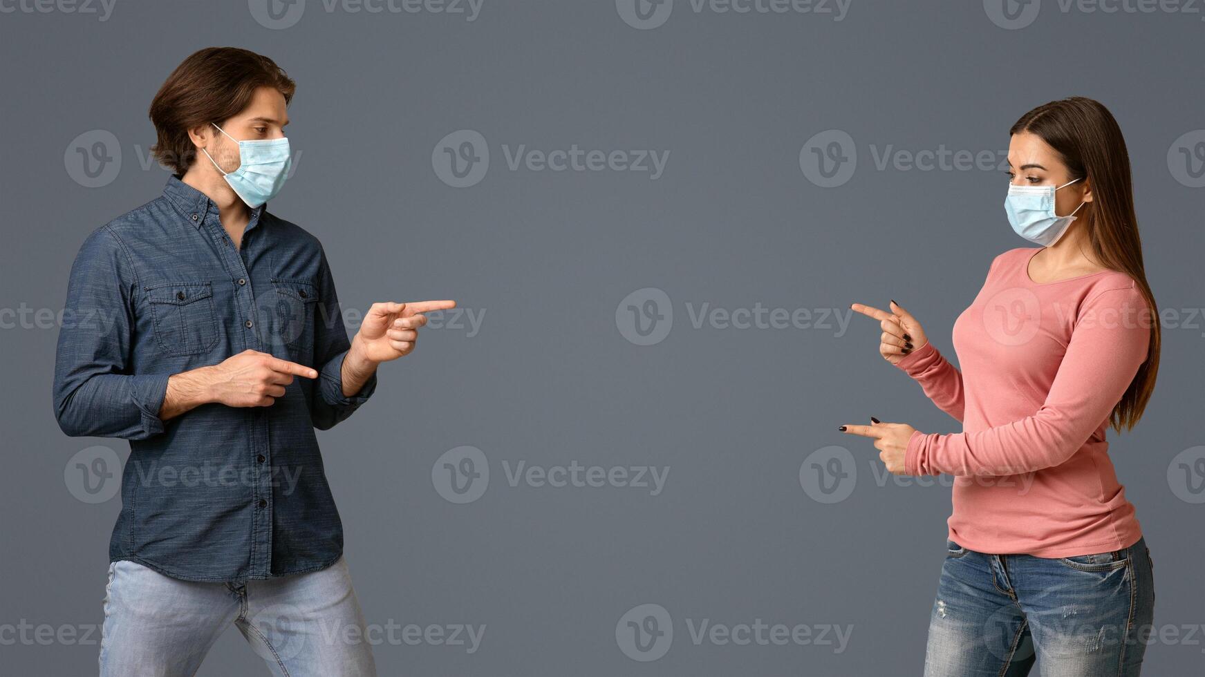 Current Information About COVID-19. Man And Woman In Medical Masks Pointing At Copy Space In The Middle Of Background, Panorama photo