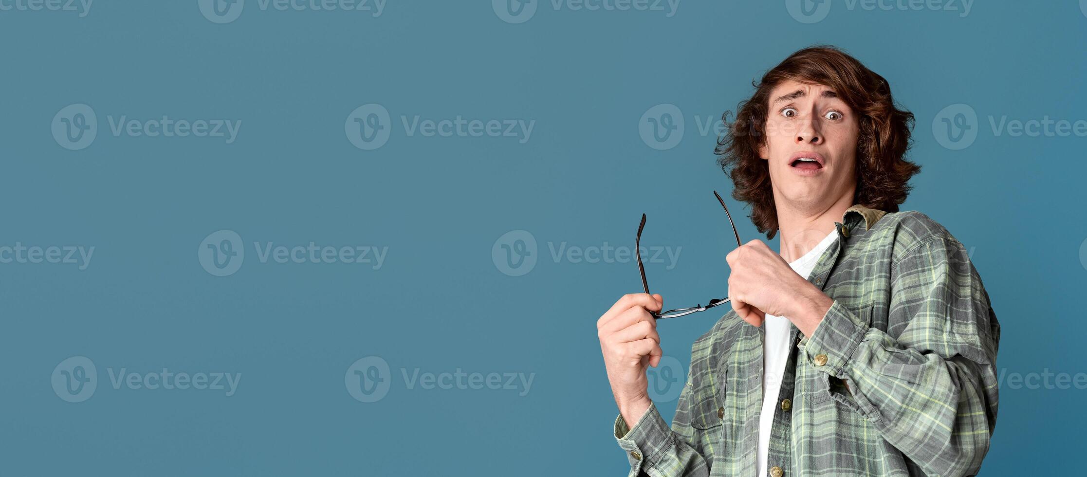 Stress control concept. Anxious Caucasian teenager with panicked expression on turquoise background photo
