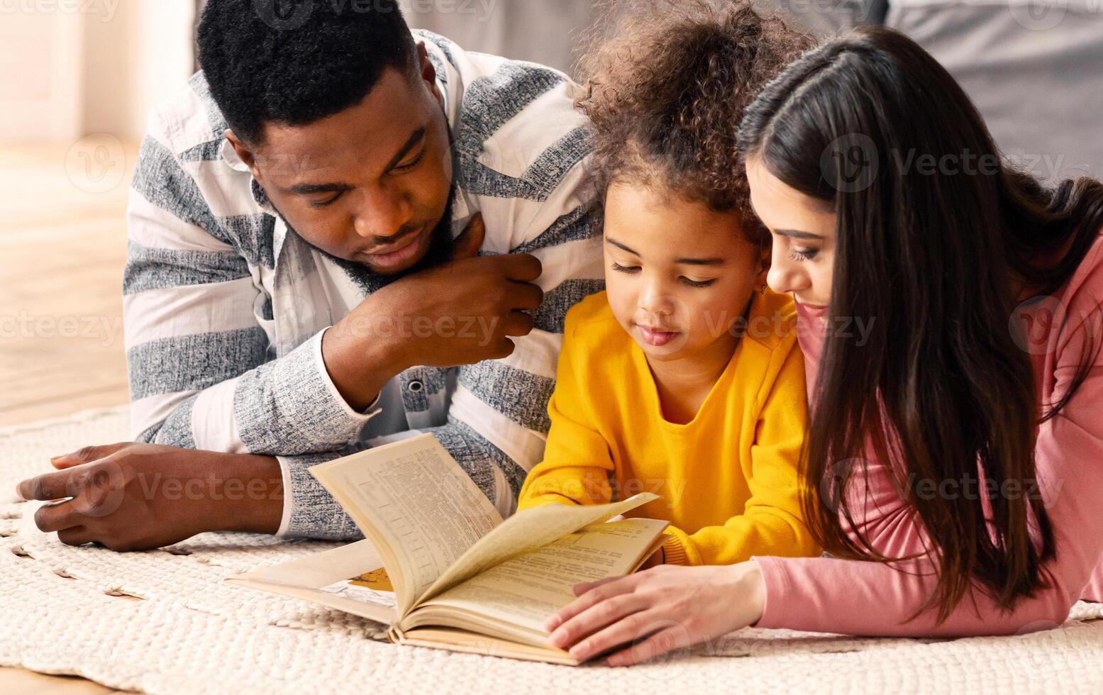 Reading lessons in an international family on the floor at home during covid-19 quarantine photo