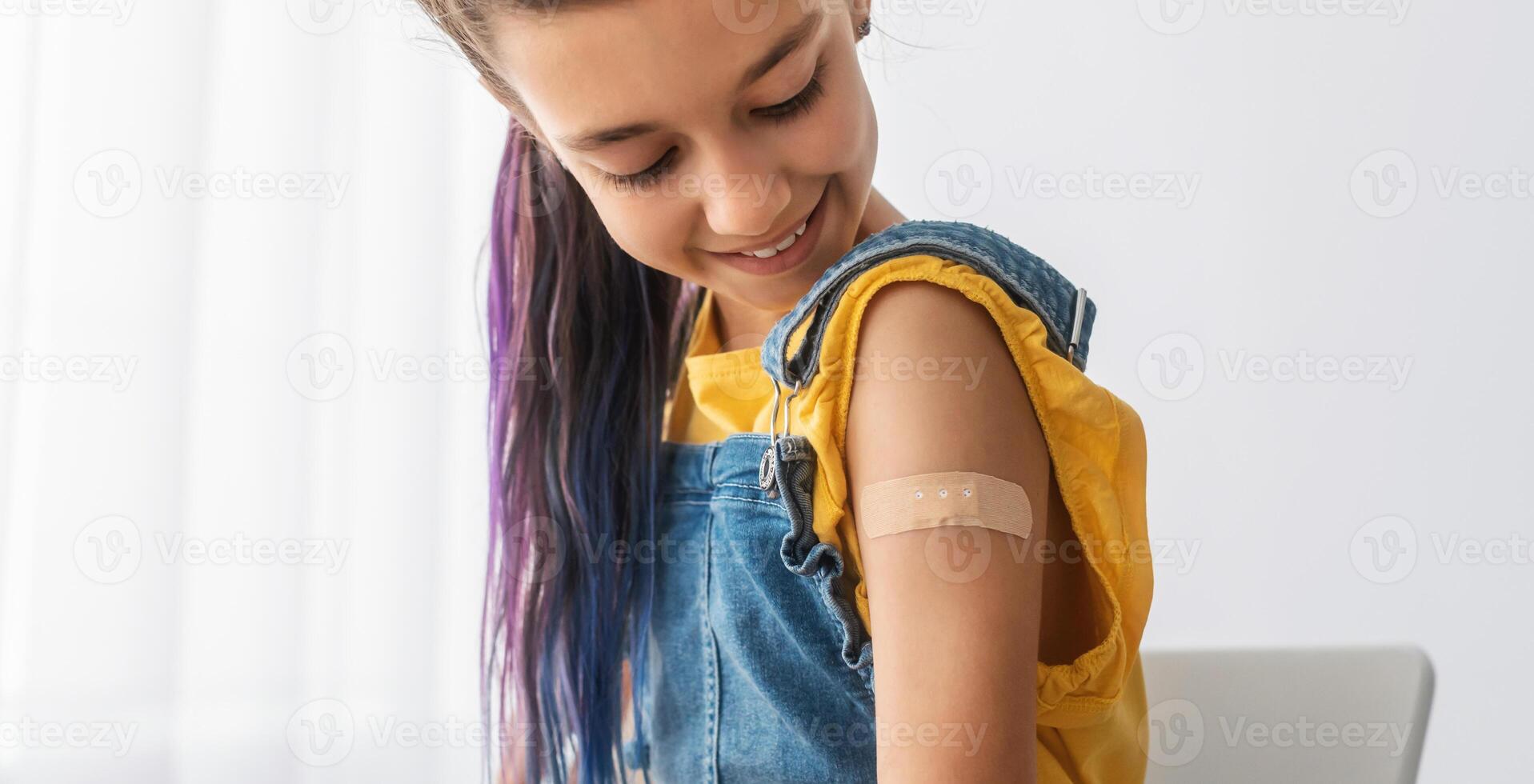 Healthcare And Inoculation Concept. Portrait Of Smiling Teen Patient Showing Vaccinated Arm With Plaster On Shoulder After Coronavirus Vaccination, Looking At Hand. Antiviral Vaccine, Banner, Panorama photo