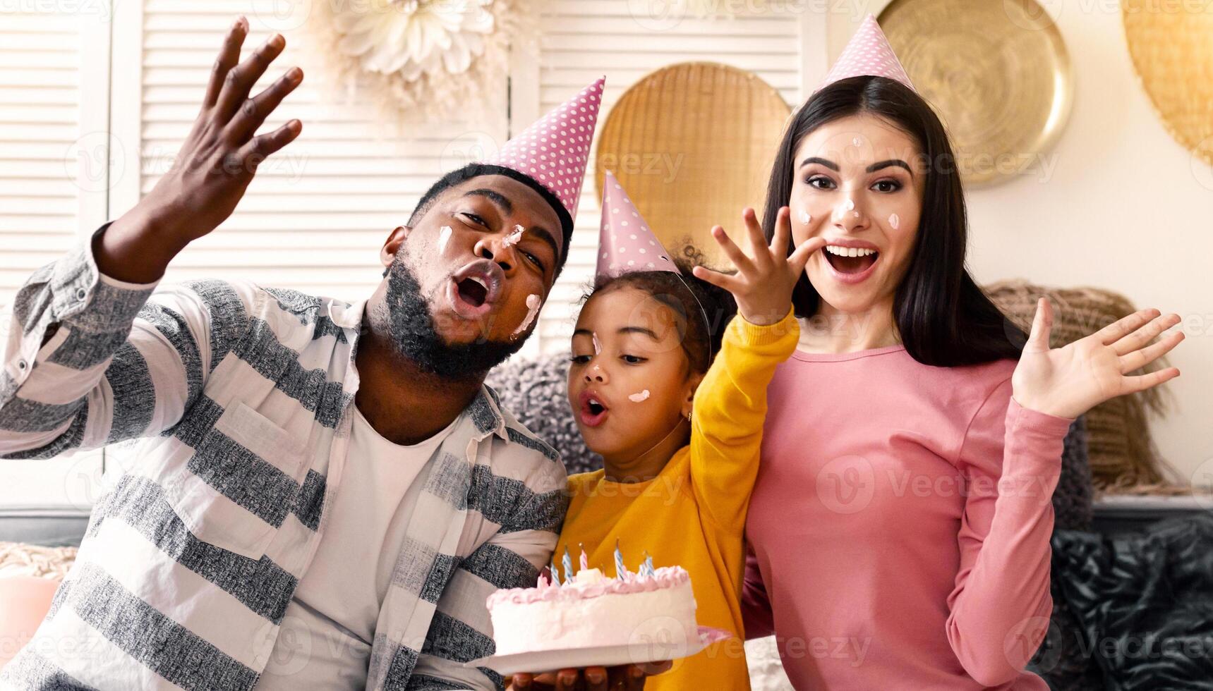 International family in caps smeared in cake and sing song photo