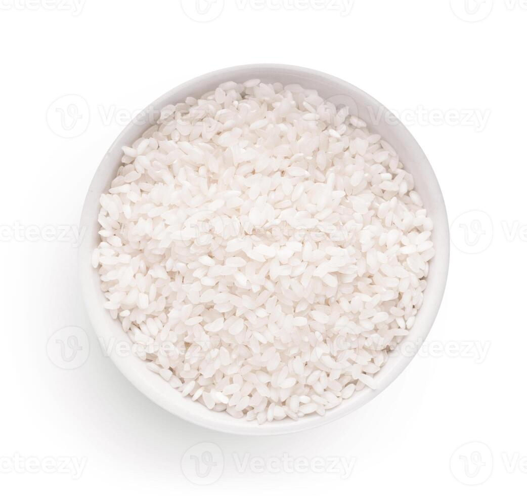 Raw dry rice in bowl isolated on white background, top view. Main asian food ingredient photo