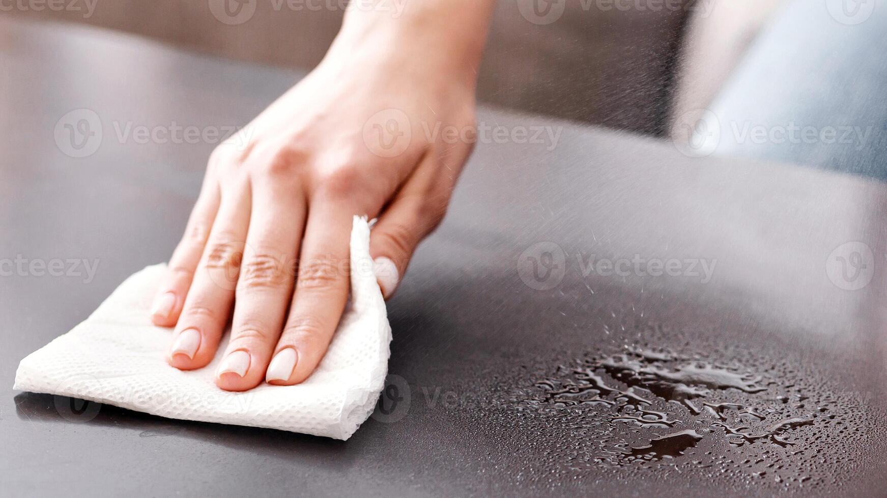 Disinfection at home. Girl wipes table with antiseptic and sponge photo